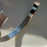 925 Sterling Silber Armreif mit individueller Gravur zeigt eine tief eingearbeitete personalisierte Botschaft auf der glaenzenden Oberflaeche und praezise Gravurlinien als Ausdruck hochwertiger Handwerkskunst von Sprezzi Fashion