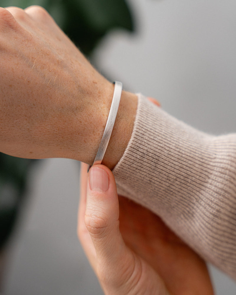 Am Handgelenk zeigt der Armreif eine minimalistische Form und dezente Raw Struktur die maskulinen modernen Stil erzeugt Sprezzi Fashion