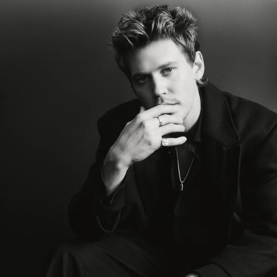 Austin Butler mit feiner Halskette und kleinem Anhänger sowie schmalen Ringen zu einem schwarzen Herren Look als reduziertes Schmuck Layering Sprezzi Fashion