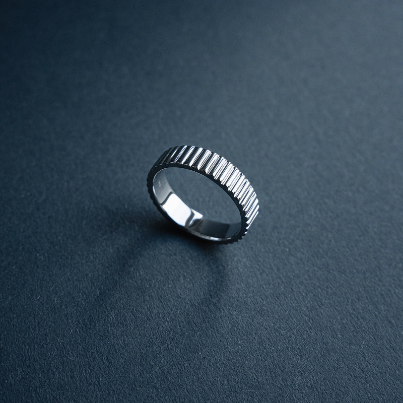 Der schmale Bandring Linear aus massivem 925 Sterling Silber zeigt eine dezente geriffelte Struktur mit klaren Linien und moderner minimalistisch eleganter Form die ein ruhiges architektonisches Design vermittelt und Maennern einen stilvollen praesenten Ausdruck bietet Sprezzi Fashion