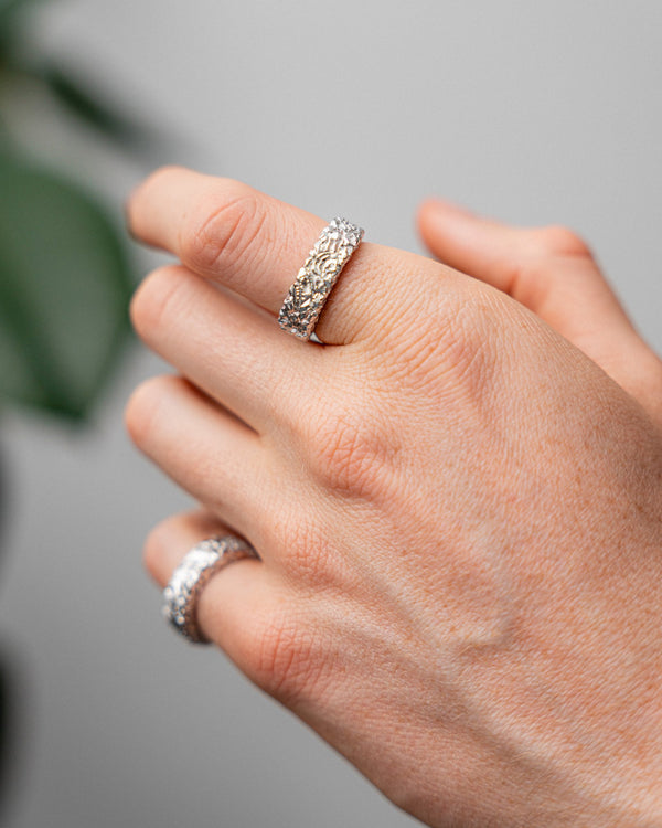 Der getragene Ring zeigt massive Form und meteoritenartige Textur die stilvollen maennlichen Ausdruck schafft Sprezzi Fashion