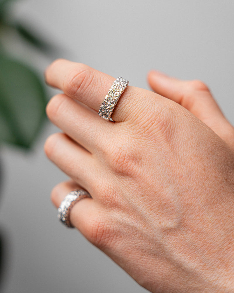 Der getragene Ring zeigt massive Form und meteoritenartige Textur die stilvollen maennlichen Ausdruck schafft Sprezzi Fashion