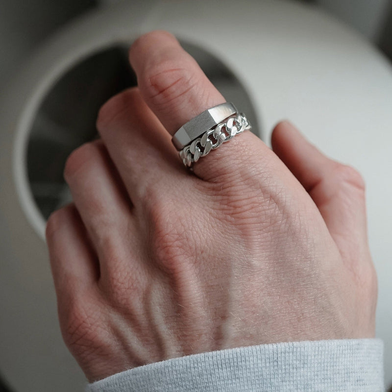 Der getragene Chain Ring aus Silber mit seiner markanten Gliederstruktur steht neben dem Raw Thin Ring dessen handgravierte Oberflaeche einen modernen Kontrast bildet sodass ein kraftvoller maennlicher Set Look entsteht Sprezzi Fashion