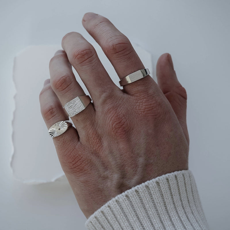 Getragen erscheinen der breite Raw Ring der schmale Raw Thin Ring und der Sunray Siegelring als harmonisches Set das raue Struktur poliertes Silber und dezente Details zu einem kraftvollen modernen Stil verbindet Sprezzi Fashion