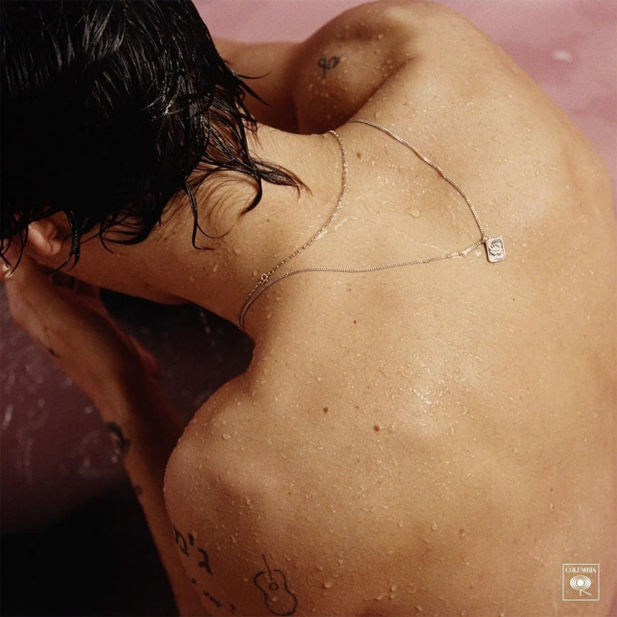Harry Styles mit zwei feinen Halsketten in unterschiedlichen Längen und kleinem rechteckigem Anhänger als dezentes Ketten Layering Sprezzi Fashion