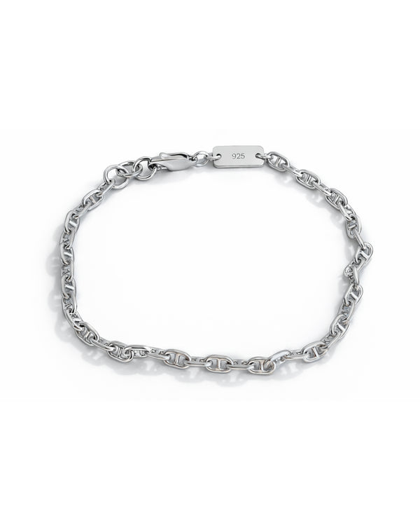 Nahaufnahme eines minimalistischen Silberarmbands Herren aus 925 Sterling Silber im Cable Link Design, dessen schmale Gliederstruktur das Licht sanft reflektiert und eine klare, moderne Ausstrahlung zeigt Sprezzi Fashion