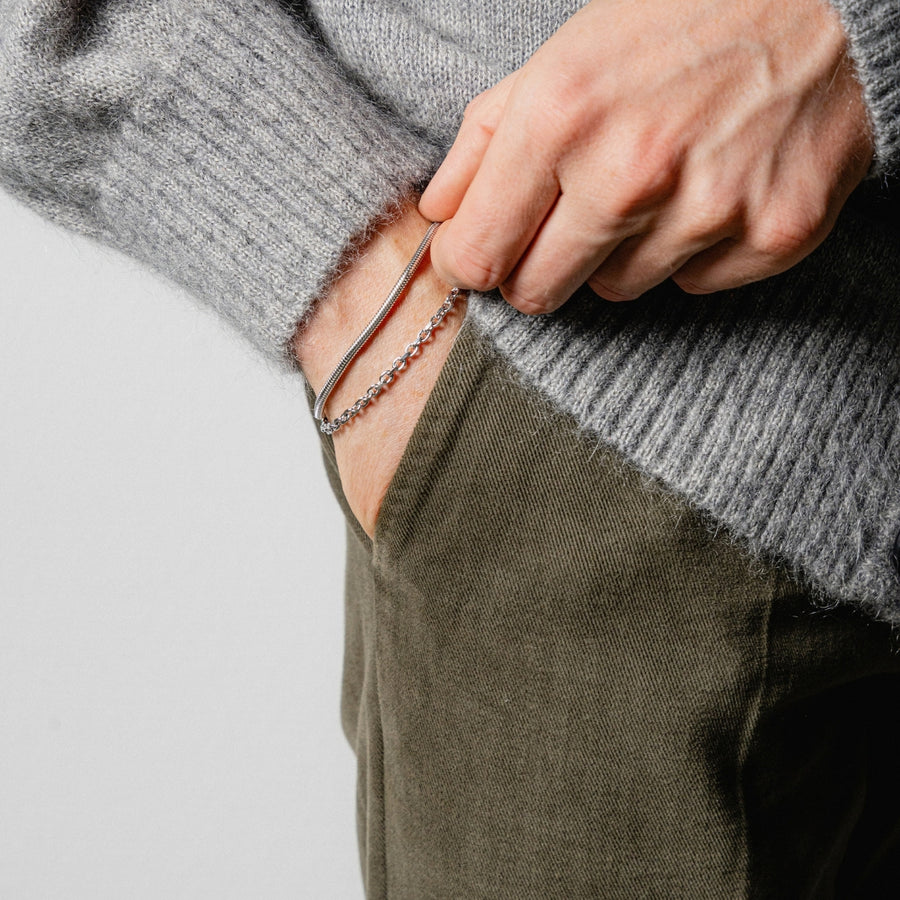 Armband Layering für Herren mit zwei silbernen Armbändern in unterschiedlichen Breiten und Gliederformen am Handgelenk Sprezzi Fashion