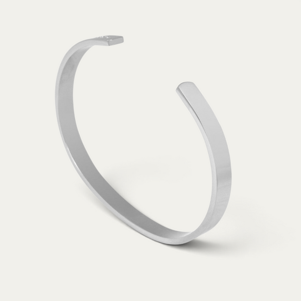 Brazalete para hombre de acero inoxidable color plateado con superficie lisa y pulida y brillo uniforme, que combina un diseño definido con una discreta apariencia masculina moderna Sprezzi Fashion