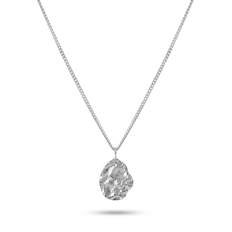 Zu sehen ist ein ovaler Anhaenger aus 925 Silber dessen rhodinierte meteoritenartige Struktur moderne technische Aesthetik erzeugt und klare Linien mit reduzierter futuristischer Praesenz verbindet wodurch ein charakterstarkes Herrenaccessoire entsteht Sprezzi Fashion