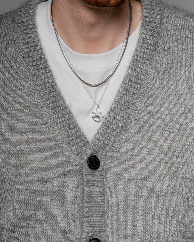 Ein Mann traegt zwei Halsketten aus 925 Sterling Silber eine mit gehaemmertem Anhaenger und eine im Snake Design die Kombination wirkt kraftvoll modern und elegant Sprezzi Fashion