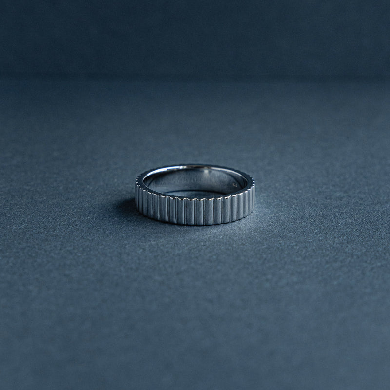 Der Bandring Linear zeigt ein hochwertiges Design aus poliertem 925 Sterling Silber mit dezenter geriffelter Struktur die eine ruhige minimalistische Ausstrahlung schafft und perfekte Harmonie zwischen modernem Stil und schlichter Eleganz erzeugt Sprezzi Fashion