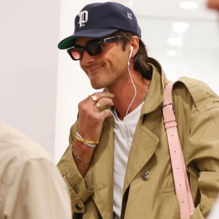 Jacob Elordi mit mehreren Ringen und Armbändern zu einem lässigen Trenchcoat Look als zurückhaltendes Schmuck Layering für Herren Sprezzi Fashion