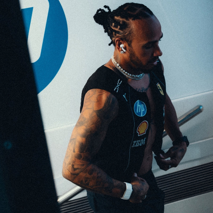 Lewis Hamilton mit mehreren Perlen und Metallketten als auffälliges Ketten Layering zu einem sportlichen Herren Look Sprezzi Fashion