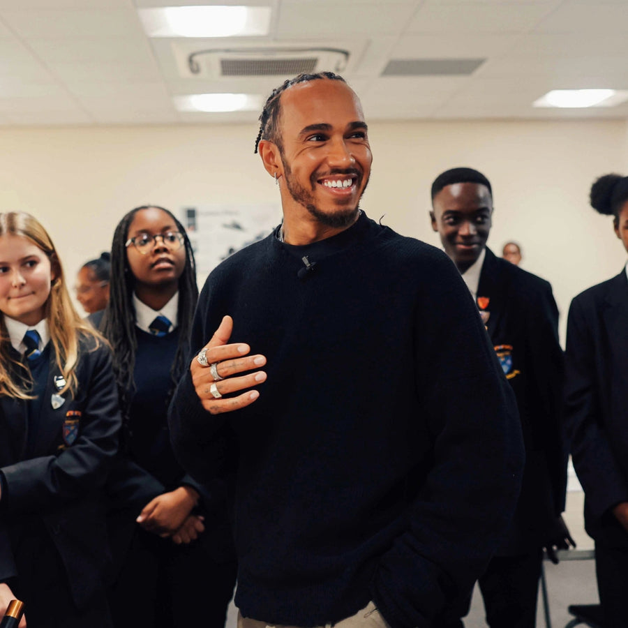 Lewis Hamilton mit mehreren markanten Silberringen an einer Hand als modernes Ring Layering zu einem schlichten schwarzen Herren Outfit Sprezzi Fashion
