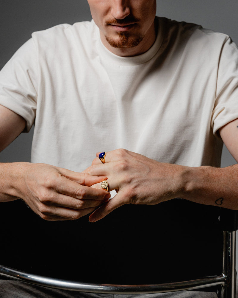 Ein Mann traegt den Kompassrose Ring und den Lapislazuli Ring beide aus 925 Silber mit 18k Vergoldung die Gravur der Kompassrose steht im Mittelpunkt Sprezzi Fashion