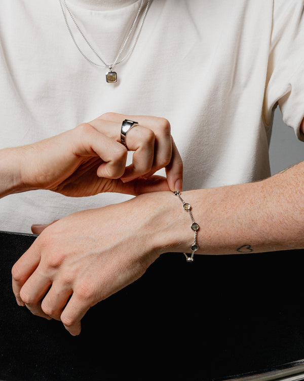 Ein Mann traegt das Silber Armband mit Larvikit Stein aus 925 Sterling das Licht spiegelt auf dem schimmernden Edelstein und dem glaenzenden Metall Sprezzi Fashion