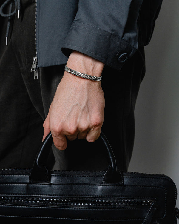 Ein Mann traegt den Roman Armreif aus 925 Sterling Silber mit feiner Lorbeergravur das Design verbindet antike Inspiration und moderne maskuline Eleganz Sprezzi Fashion