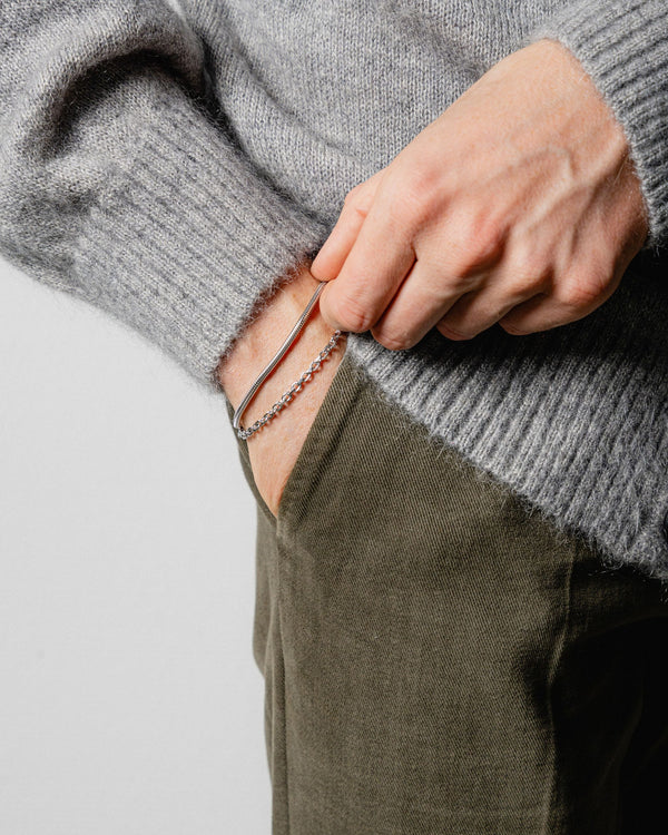 Ein Mann traegt zwei Armbänder Toggle und Snake aus 925 Silber die Kombination aus glatter Struktur und markantem Verschluss steht fuer modernen Stil Sprezzi Fashion