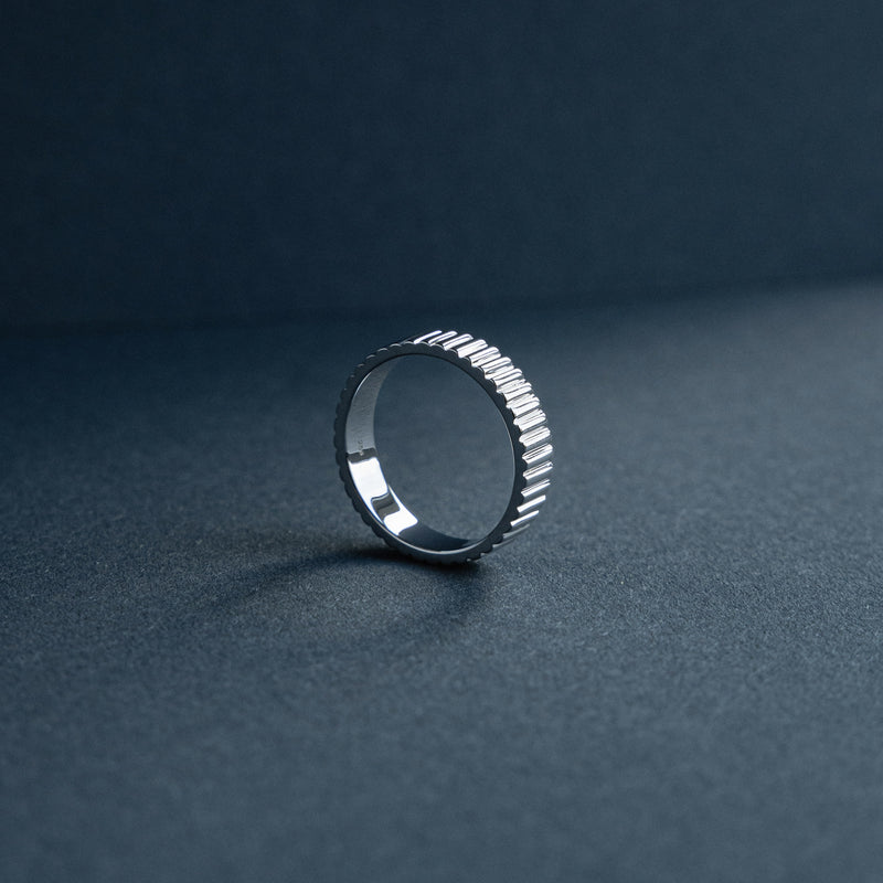 Dieser Bandring praesentiert eine gleichmaessige Struktur aus massivem 925 Sterling Silber und verbindet glatte Flaechen mit feinem Rillenmuster wodurch ein moderner reduzierter Stil entsteht der zeitlose Eleganz und architektonische Praezision ausstrahlt Sprezzi Fashion