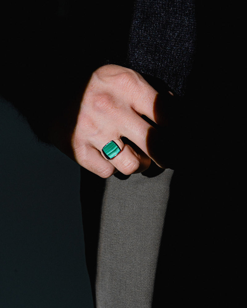 Model traegt den grünen Malachit Siegelring aus 925 Sterling Silber gefertigt in feiner Handarbeit von Sprezzi Fashion der Edelstein strahlt Tiefe und Eleganz Sprezzi Fashion