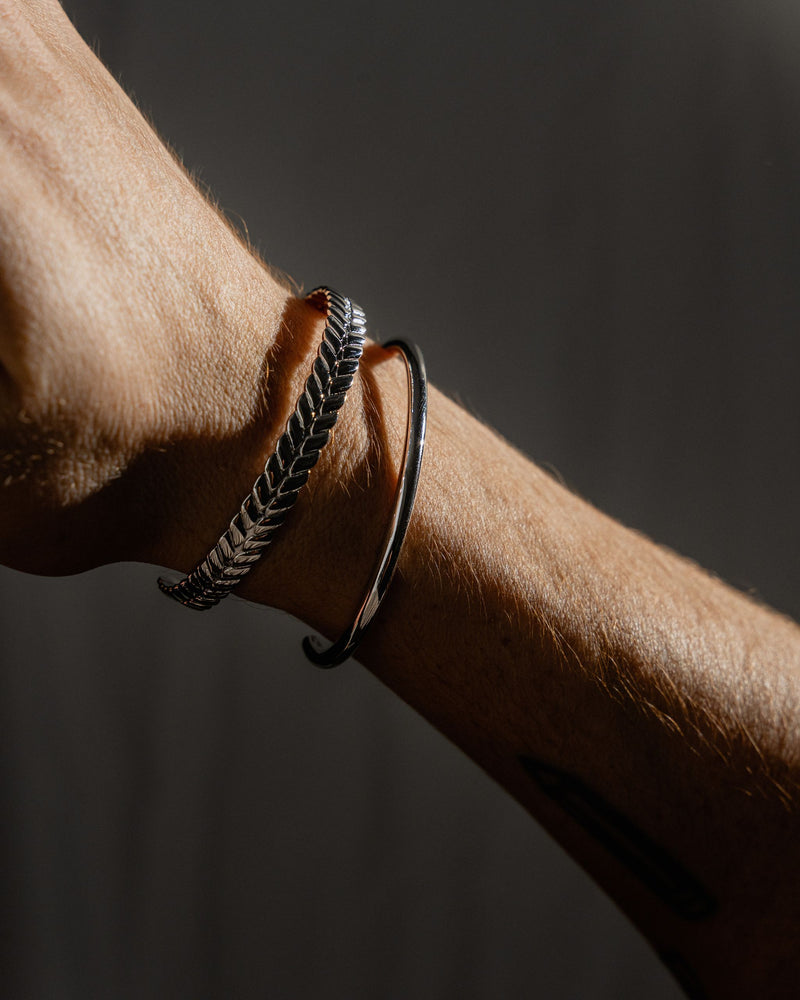 Model traegt Roman und Clean Minimal Armreife aus 925 Silber gefertigt in feiner Handarbeit von Sprezzi Fashion das Licht hebt Gravur und Glanz hervor Sprezzi Fashion