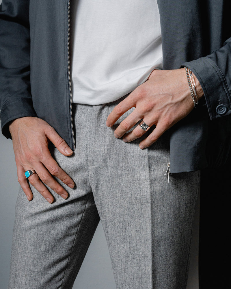 Model traegt Tuerkis Siegelring und Notch Ring gefertigt in feiner Handarbeit von Sprezzi Fashion der Naturstein und das Zacken Muster erzeugen Kontrast Sprezzi Fashion