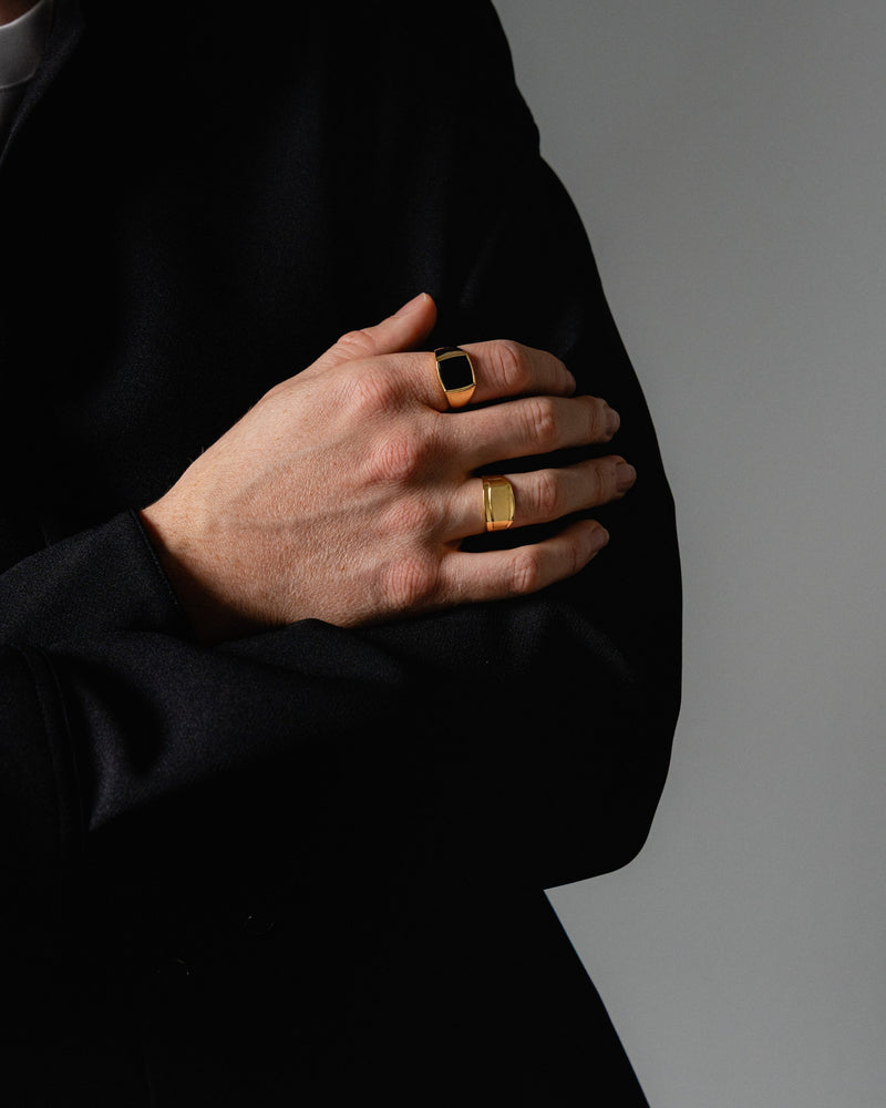 Nahaufnahme zeigt einen Mann mit goldenem Siegelring und Edgy Ring gefertigt aus 925 Silber mit Echtgold die feinen Linien und der Onyx Stein glaenzen Sprezzi Fashion