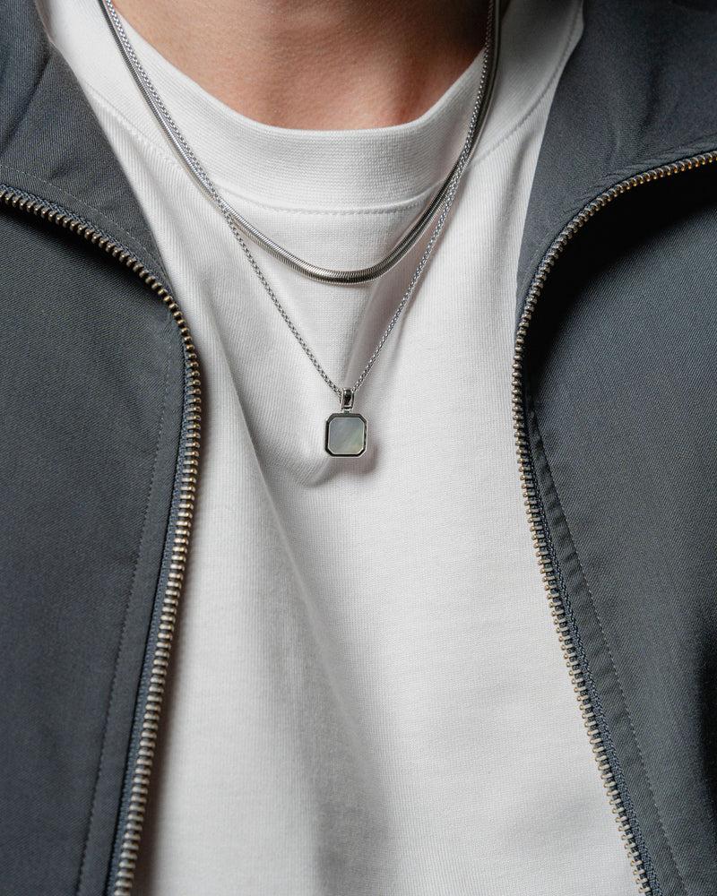 Nahaufnahme zeigt einen Mann der Snake Chain und Aqua Halsketten aus 925 Silber traegt der blaue Stein reflektiert sanftes Licht und verleiht frische Eleganz Sprezzi Fashion