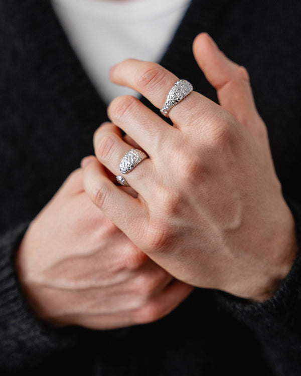 Am Finger zeigt der Ring eine offene moderne Silhouette deren meteoritenartige Textur kraftvolle Tiefe besitzt Sprezzi Fashion