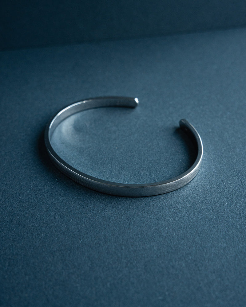 Der Armreif verbindet schlanke minimalistische Linien mit einer feinen Raw Struktur die dem massiven 925 Silber modernen Ausdruck verleiht waehrend die oeffnung fuer dezente Anpassbarkeit sorgt und eine ausgewogene Kombination aus Eleganz und maennlicher Tiefe bietet Sprezzi Fashion