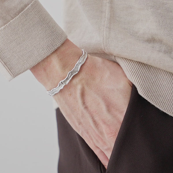 Raue meteoritartige Struktur praegt den Herren Armreif aus 925 Sterling Silber und wirkt kraftvoll technisch und maskulin am Handgelenk Sprezzi Fashion