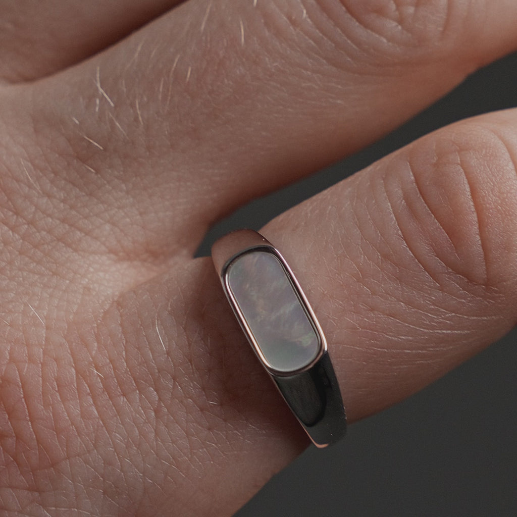 Schmaler Herrenring mit Perlmutt Stein, dessen sanfter Schimmer und helle Farbnuancen eine ruhige und minimalistische Ausstrahlung erzeugen Sprezzi Fashion