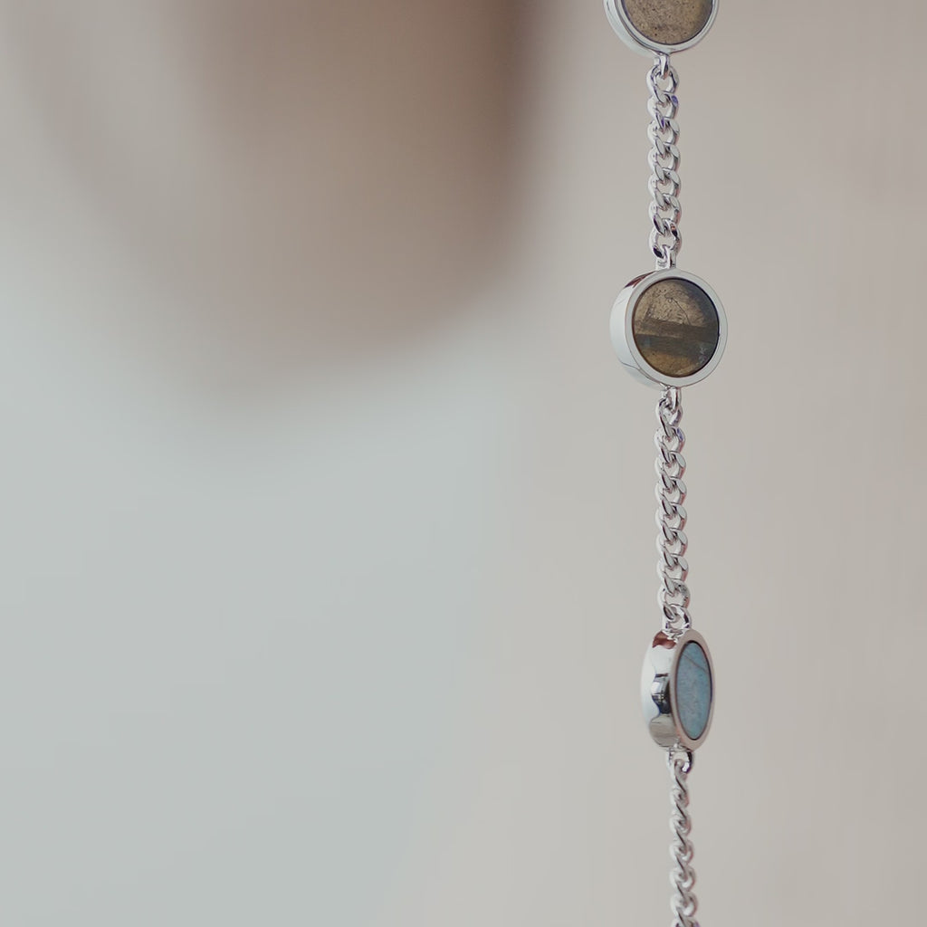 Nahaufnahme eines Herren Armbands aus 925 Sterling Silber mit mehreren runden Larvikit Steinen, die in die feine Kette eingefasst sind und je nach Licht dezente grau-grüne Nuancen zeigen Sprezzi Fashion