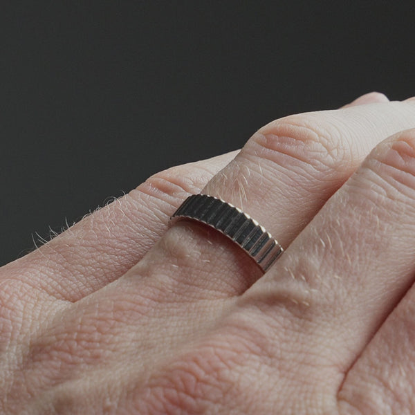 Produktvideo zeigt einen schmalen Herren Bandring aus 925 Sterling Silber mit edel verarbeiteter linearer Struktur, ruhig am Finger getragen Sprezzi Fashion