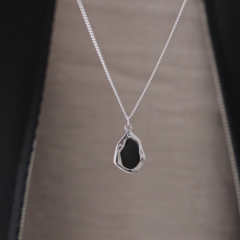 Produktvideo zeigt Herren Halskette mit schwarzem Onyx Crash Stein Anhänger aus 925 Sterling Silber in Bewegung mit markanter Steinstruktur polierter Oberfläche und kraftvoller Materialwirkung als maskulines Schmuckstück Sprezzi Fashion